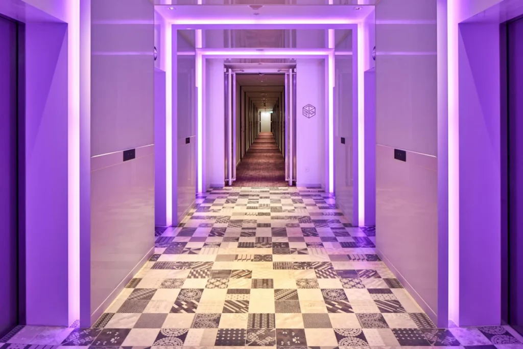 4 Best Hotels Near Changi Airport (Perfect for Layovers & Early Flights) 7 YOTELAIR Singapore Changi Airport hallway with purple ambient lighting and modern futuristic interior design