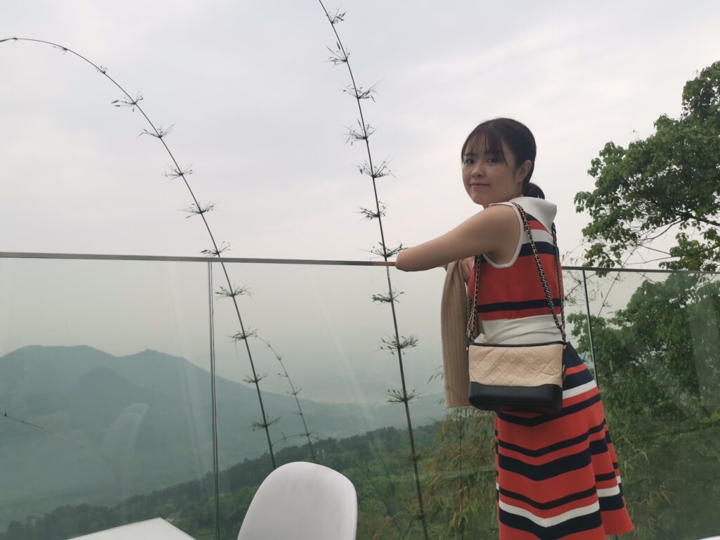 Woman enjoying scenic mountain views from Nanshan in Chongqing with glass railing overlook