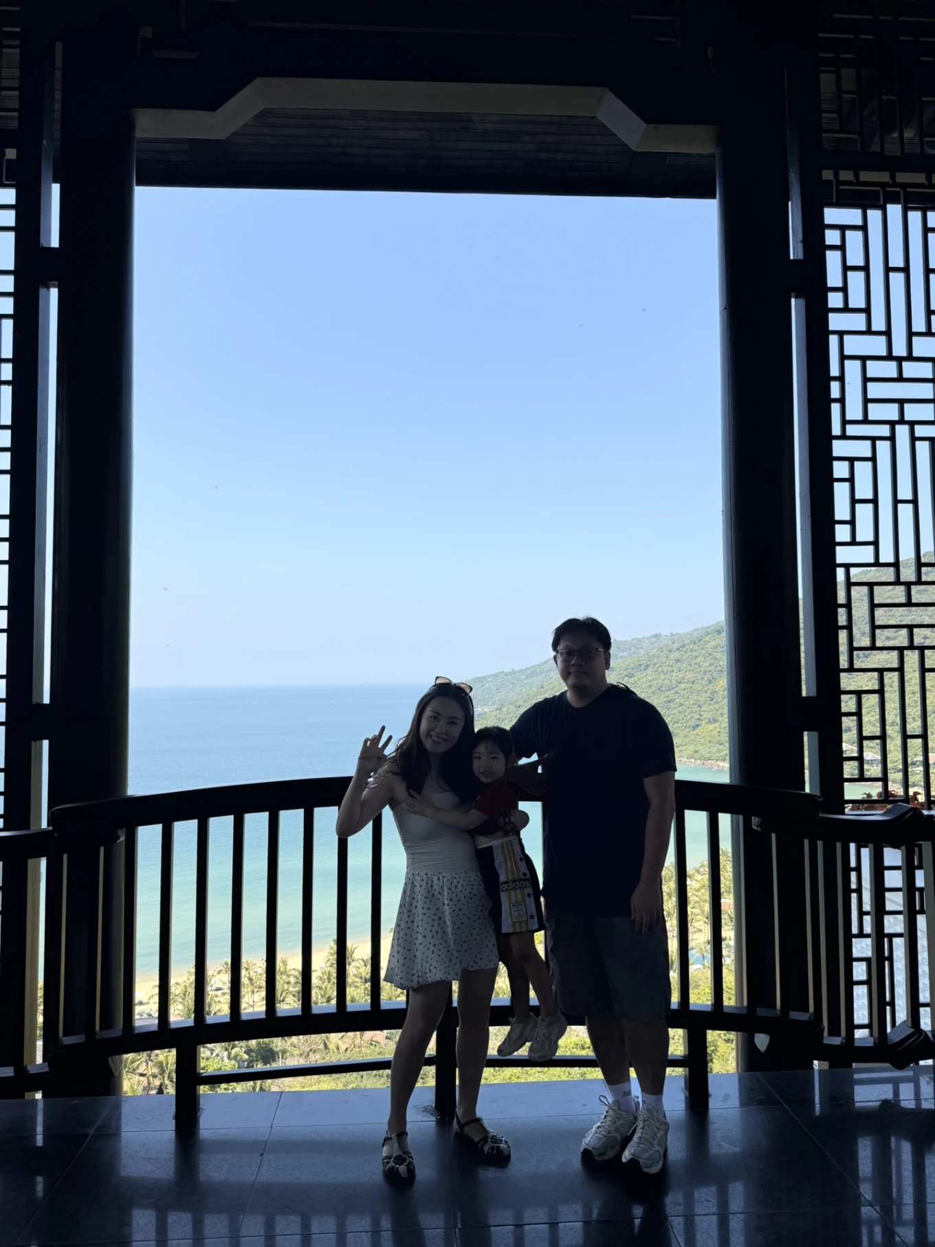 Family standing at balcony viewpoint overlooking ocean at InterContinental Danang Sun Peninsula Resort