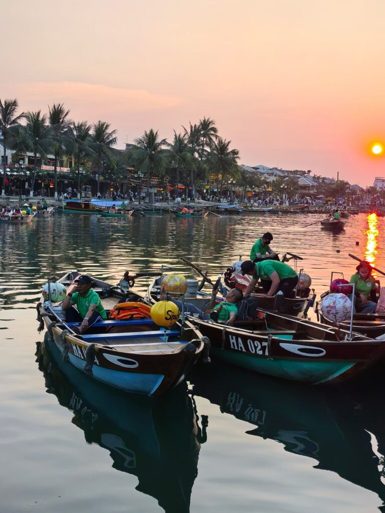 Hoi An sunset cruise on Thu Bon River with wooden boats and golden reflections
