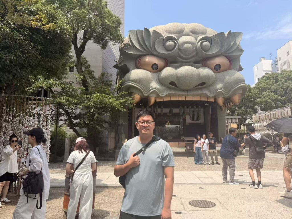 Visitor standing in front of the giant lion-head stage at Namba Yasaka Shrine, Osaka.