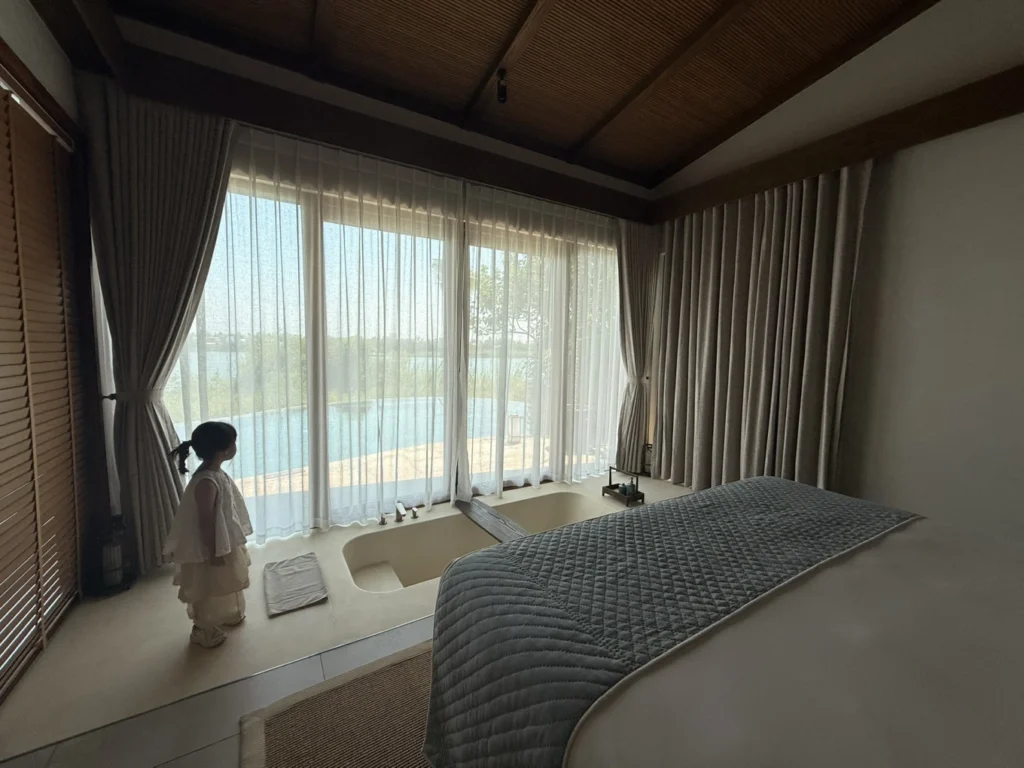 Namia River Retreat villa bedroom with bathtub and private pool view in Hoi An