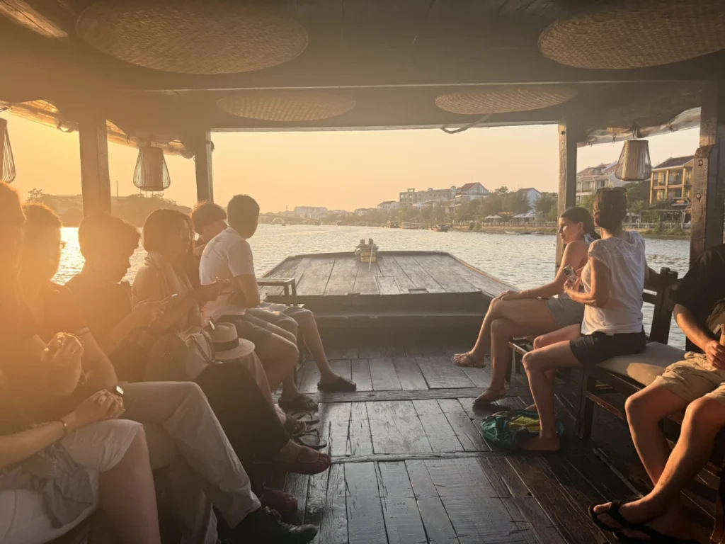 Sunset river cruise toward Hoi An Ancient Town with warm golden light