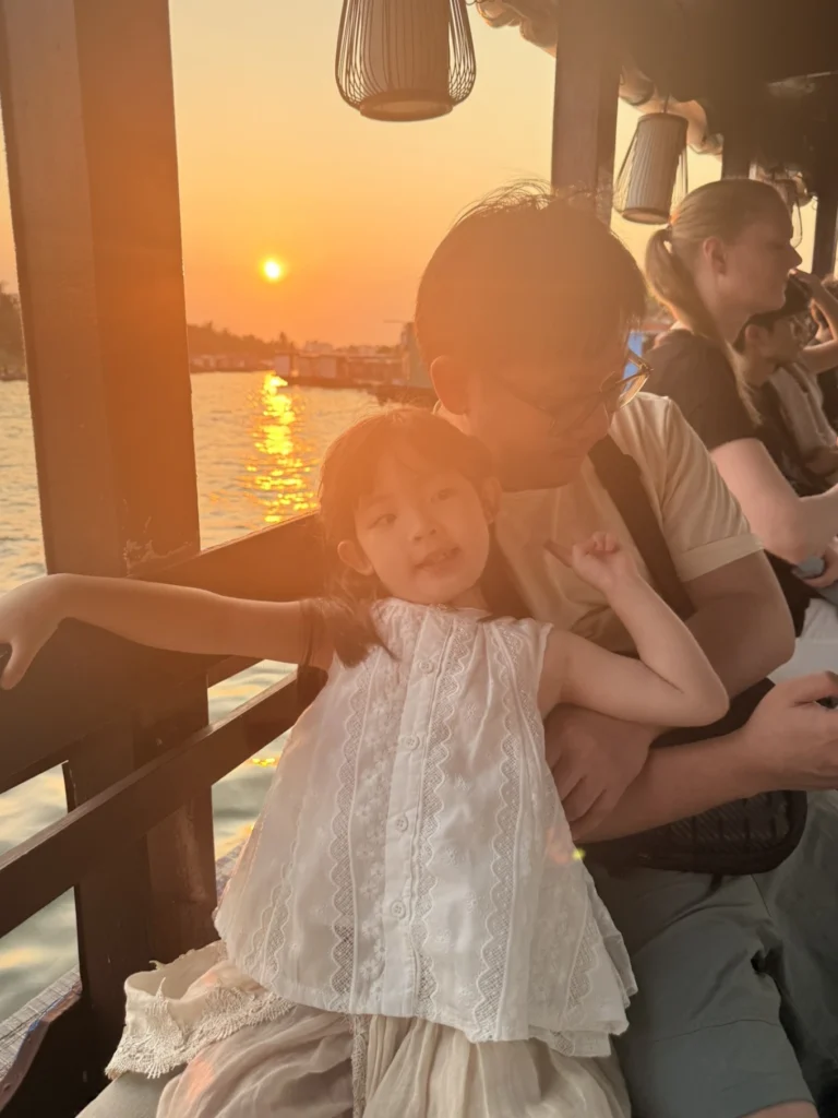 Child relaxing during sunset boat ride in Hoi An Vietnam