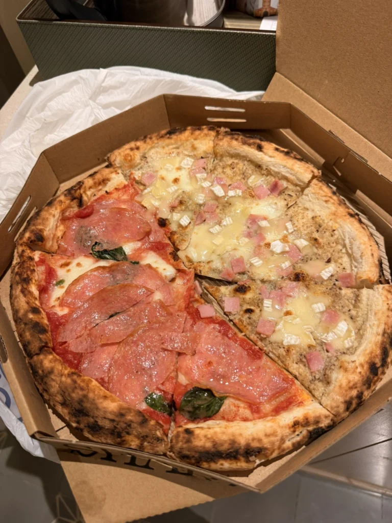 Pizza takeaway from Pizza 4P’s in Da Nang featuring thin crust pizza with cured meat and creamy cheese toppings