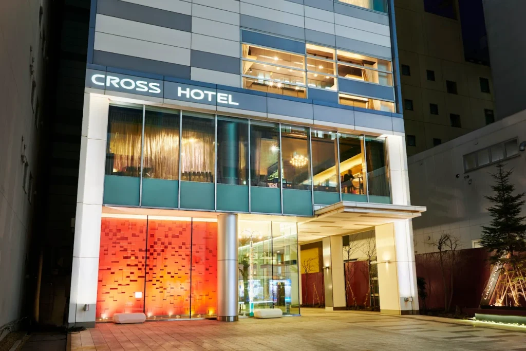 Night exterior of Cross Hotel Sapporo with illuminated modern entrance in downtown Sapporo, Japan