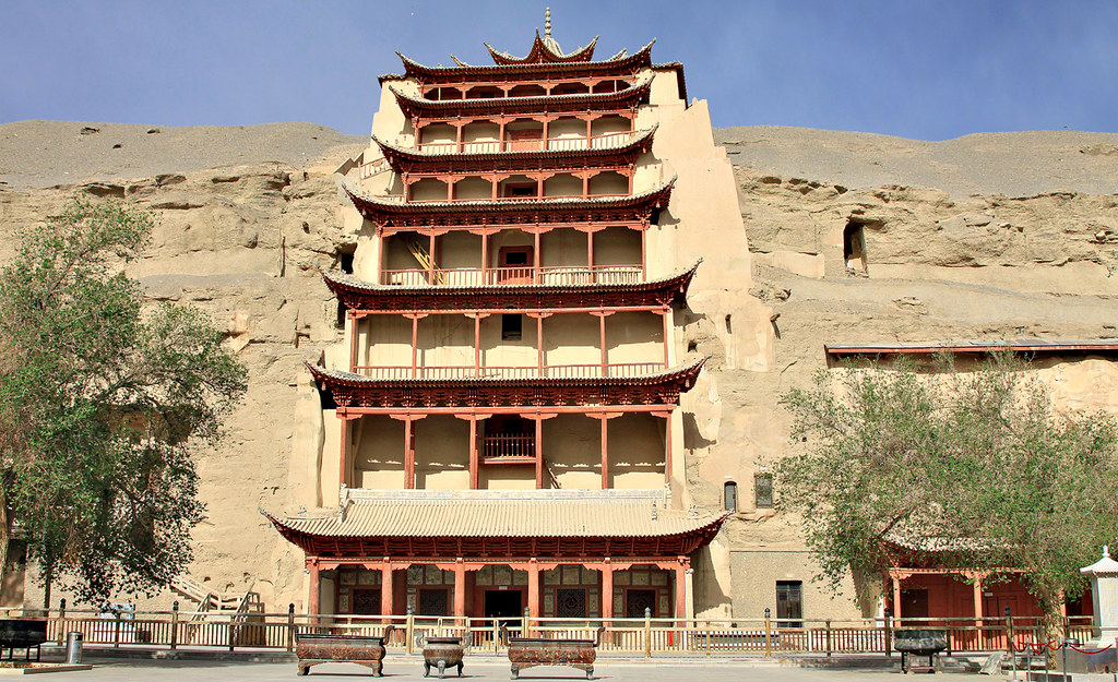 7 Underrated Cities in China Worth Visiting With Your Family 6 Historic multi-storey wooden pavilion built into desert cliffs at the Mogao Caves in Dunhuang, Gansu