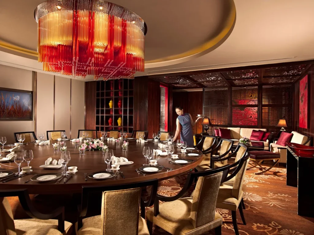 Where to Find the Best Dim Sum in Singapore (Local Picks) 13 Luxurious private dining room at Hai Tien Lo inside Pan Pacific Singapore, featuring elegant Cantonese fine dining decor.