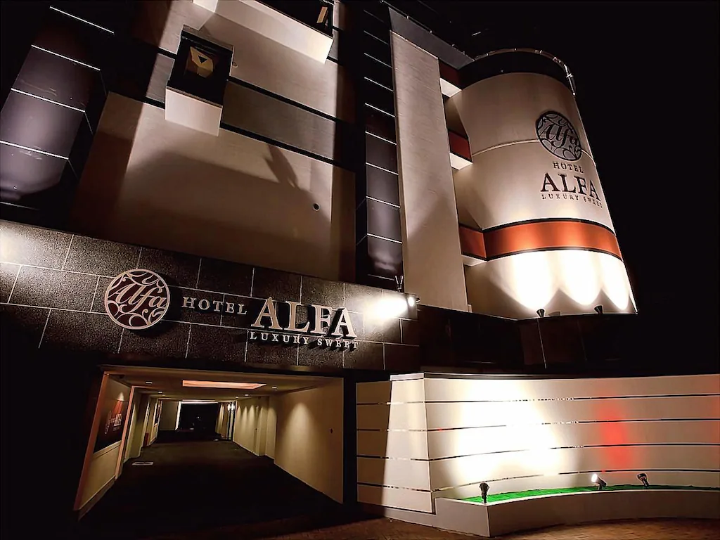 Exterior entrance of Hotel Alfa Kyoto illuminated at night, featuring modern architecture, luxury-style signage, and a sleek private driveway in Kyoto, Japan.