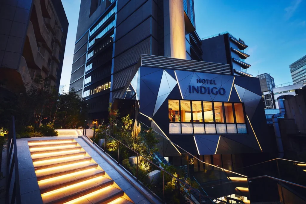 Evening exterior view of Hotel Indigo Tokyo Shibuya with illuminated entrance and modern architectural design in central Shibuya.