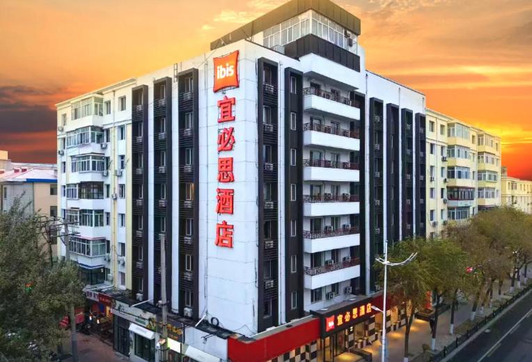 Ibis Harbin Central Street Hotel exterior at sunset with modern budget-friendly accommodation near Central Street in Harbin, China.
