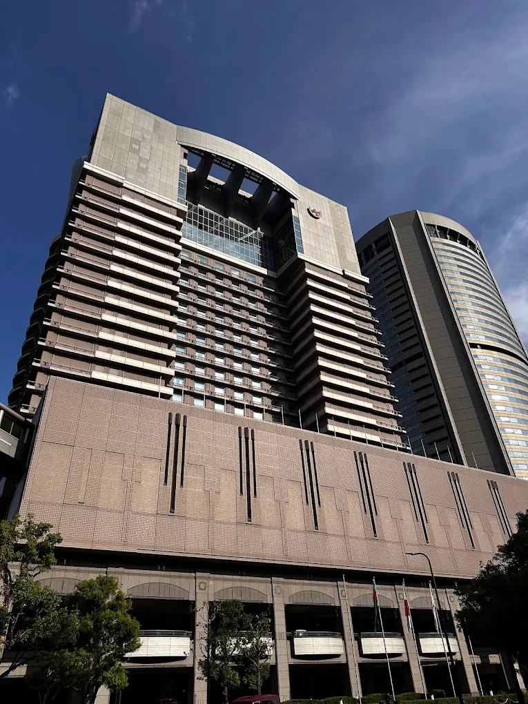 Exterior daytime view of Imperial Hotel Osaka, featuring a tall modern tower with curved architectural design against a clear blue sky.