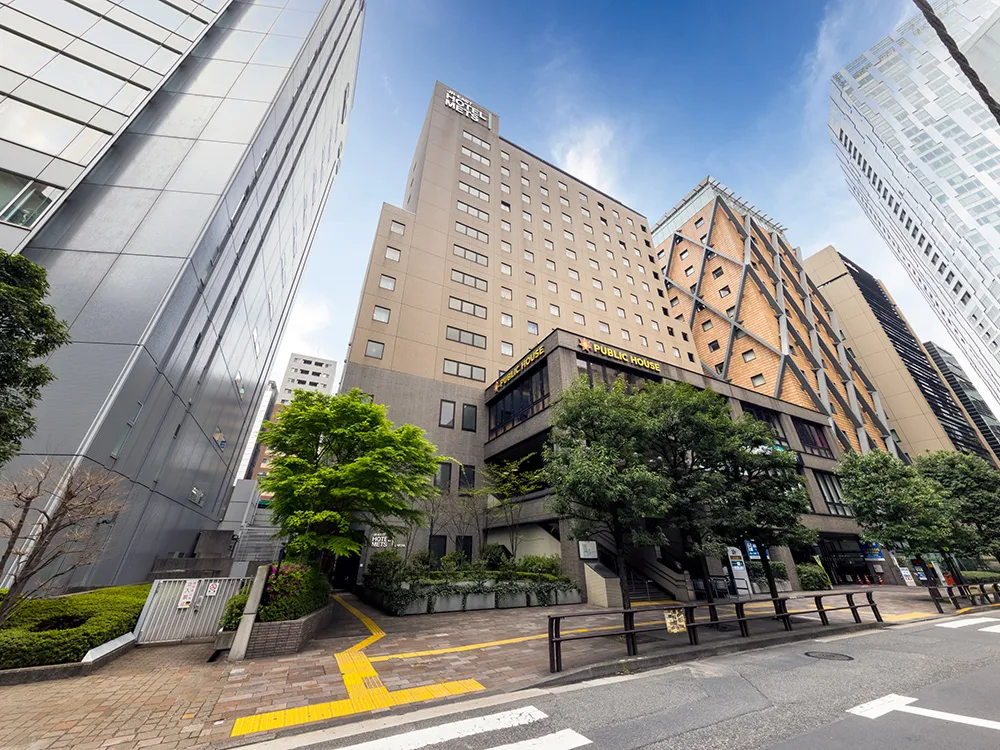 Exterior street view of JR-East Hotel Mets Shibuya surrounded by modern buildings in central Tokyo near Shibuya Station.