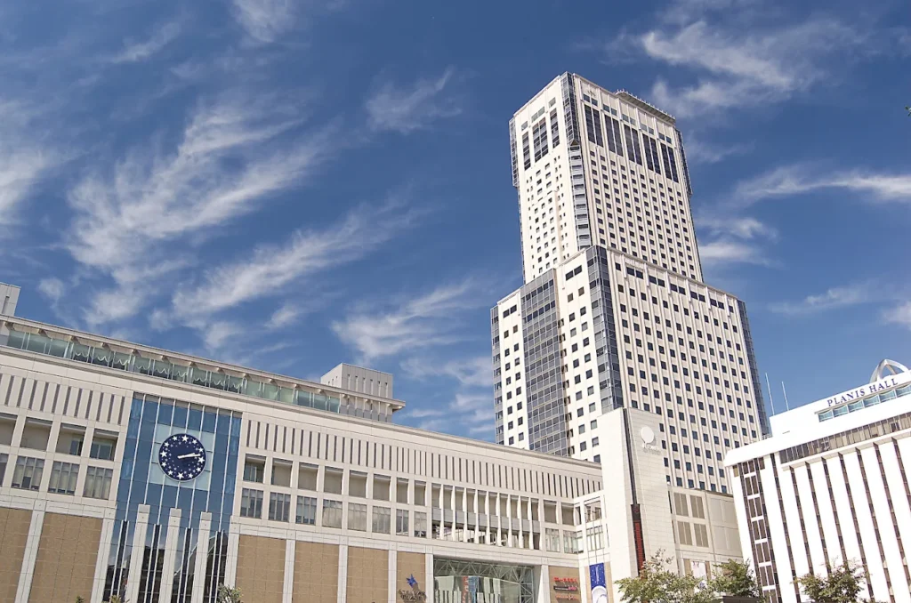 JR Tower Hotel Nikko Sapporo rising above Sapporo Station under a bright blue sky in Hokkaido, Japan