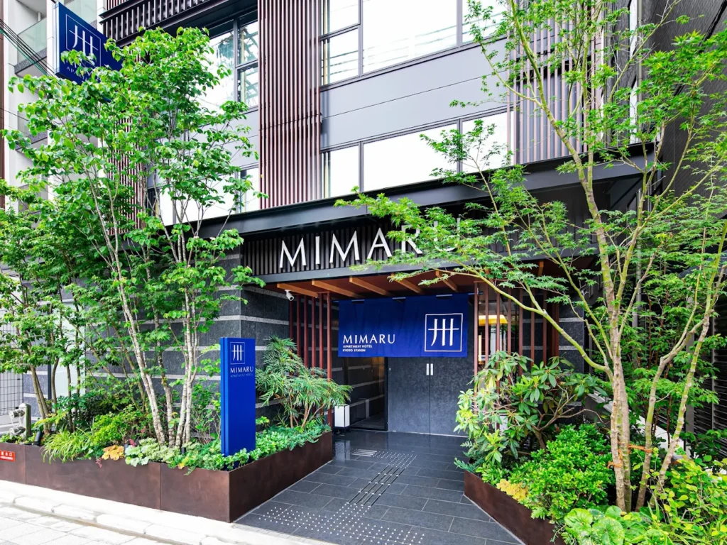 10 Best Muslim-Friendly Hotels (Halal) In Kyoto 8 Exterior entrance of MIMARU Kyoto Station apartment hotel in Kyoto, Japan, surrounded by greenery and modern Japanese architecture