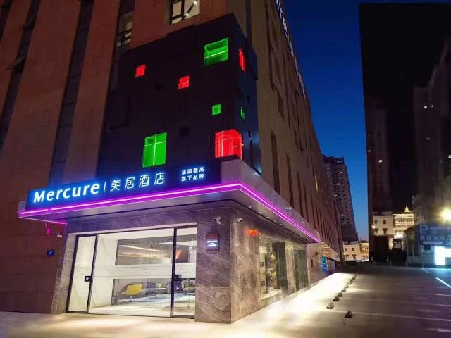 Mercure Harbin Central Street Sophia Church hotel exterior at night with colorful neon lights and modern design in Harbin, China.