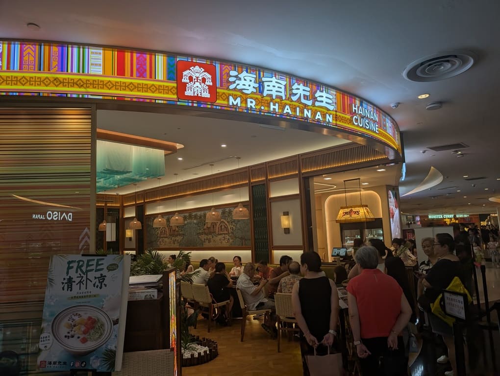 Mr Hainan VivoCity Review: Surprisingly Good Chicken Rice in Singapore 5 Exterior entrance of Mr Hainan restaurant at VivoCity Singapore with colorful signage and customers waiting outside.
