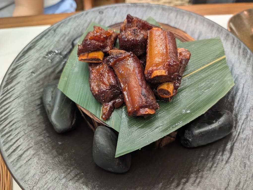 Mr Hainan VivoCity Review: Surprisingly Good Chicken Rice in Singapore 10 Caramelized pork ribs served on a banana leaf plate at Mr Hainan VivoCity.