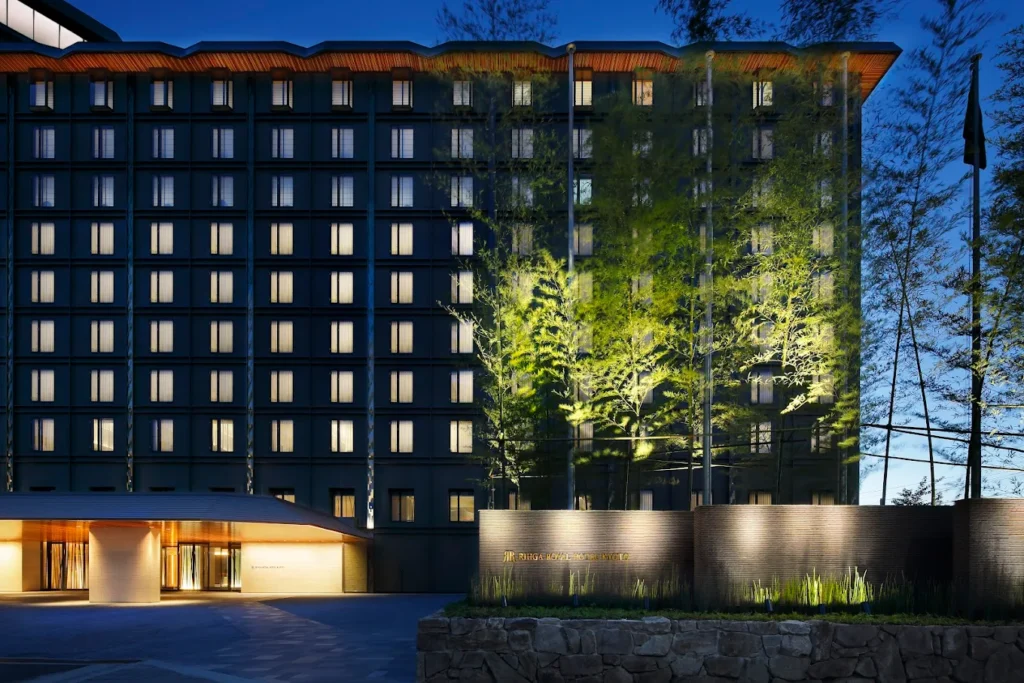10 Best Hotels Near Fushimi Inari Shrine 14 RIHGA Royal Hotel Kyoto illuminated at night with elegant modern architecture and landscaped entrance near Kyoto Station and Fushimi Inari Shrine.
