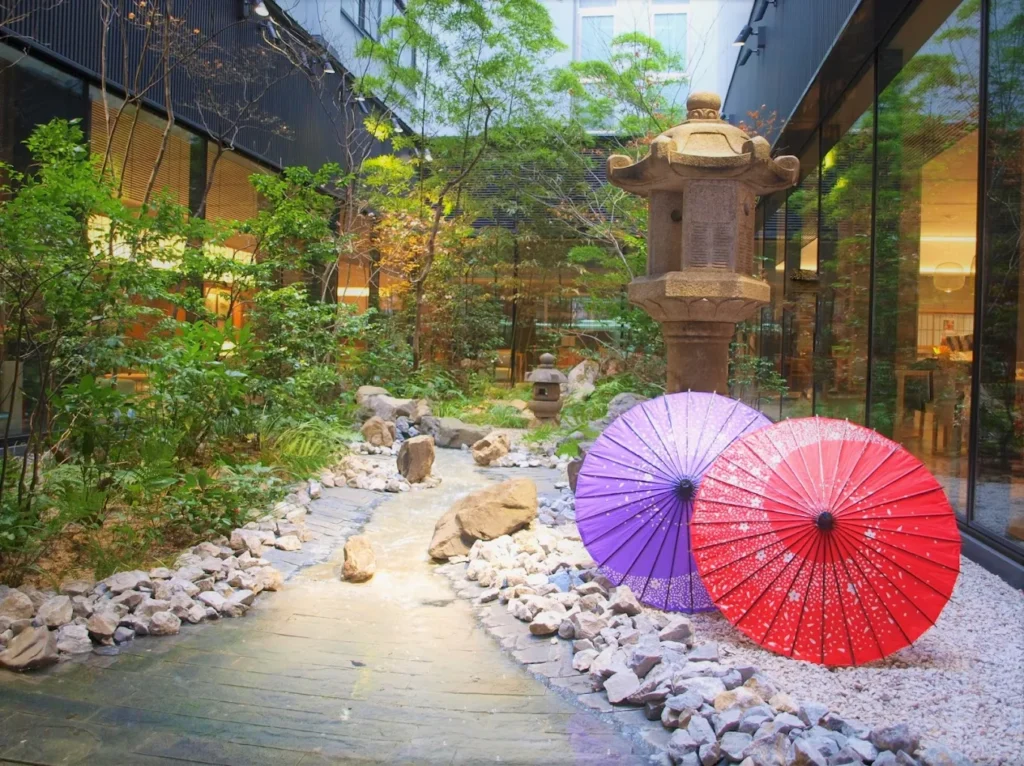 10 Best Muslim-Friendly Hotels (Halal) In Kyoto 14 Japanese garden courtyard with traditional umbrellas at Richmond Hotel Premier Kyoto Ekimae in Kyoto, Japan