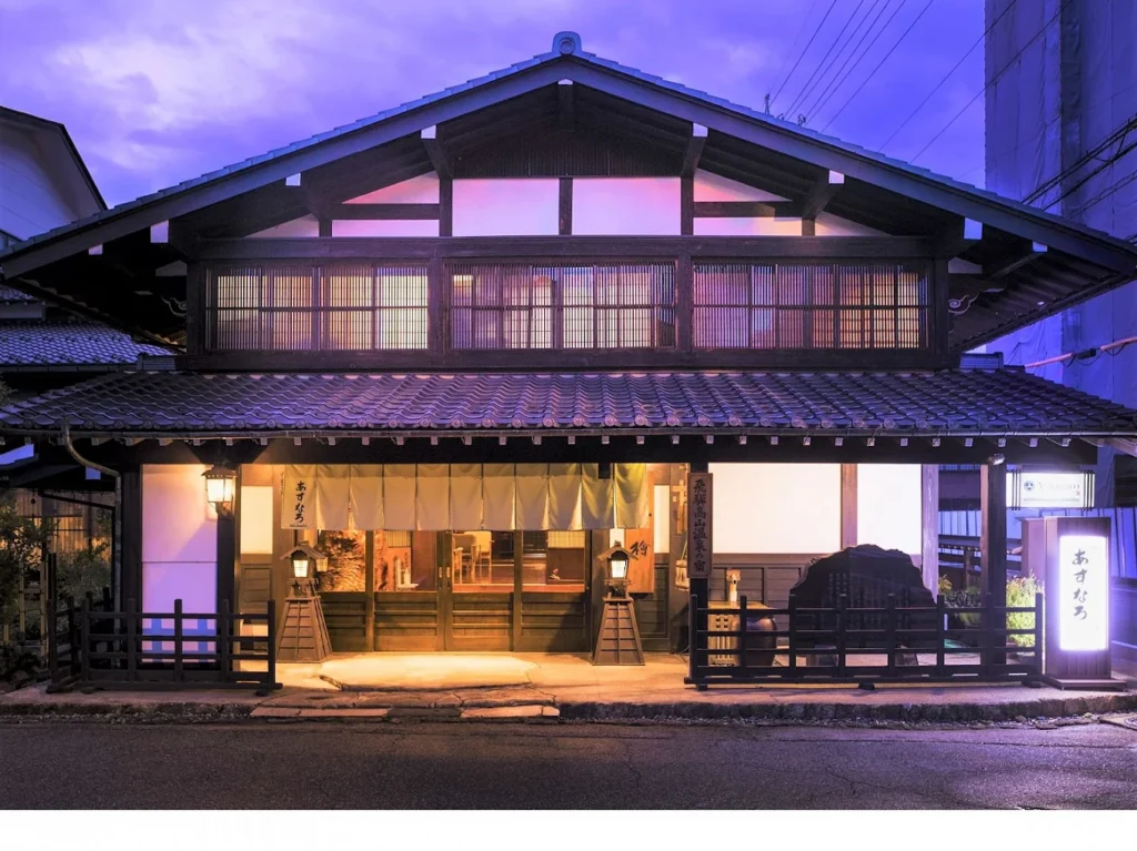 7 Best Hotels in Takayama Japan: Top Ryokans, Onsens & Family Stays 11 Traditional wooden exterior of Ryokan Asunaro in Takayama illuminated at dusk