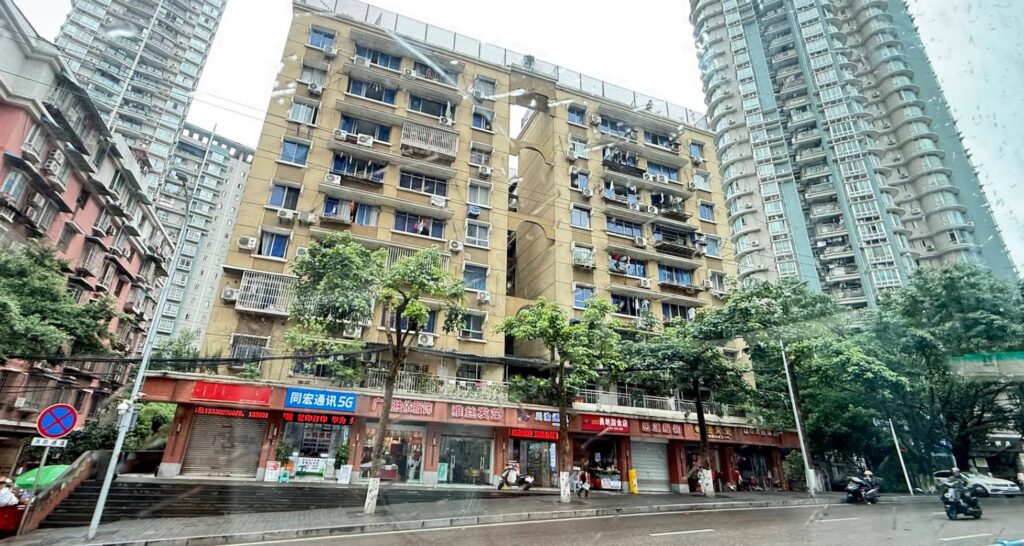 Residential neighbourhood in Shapingba District Chongqing with older apartment buildings, local shops, and modern high-rise towers