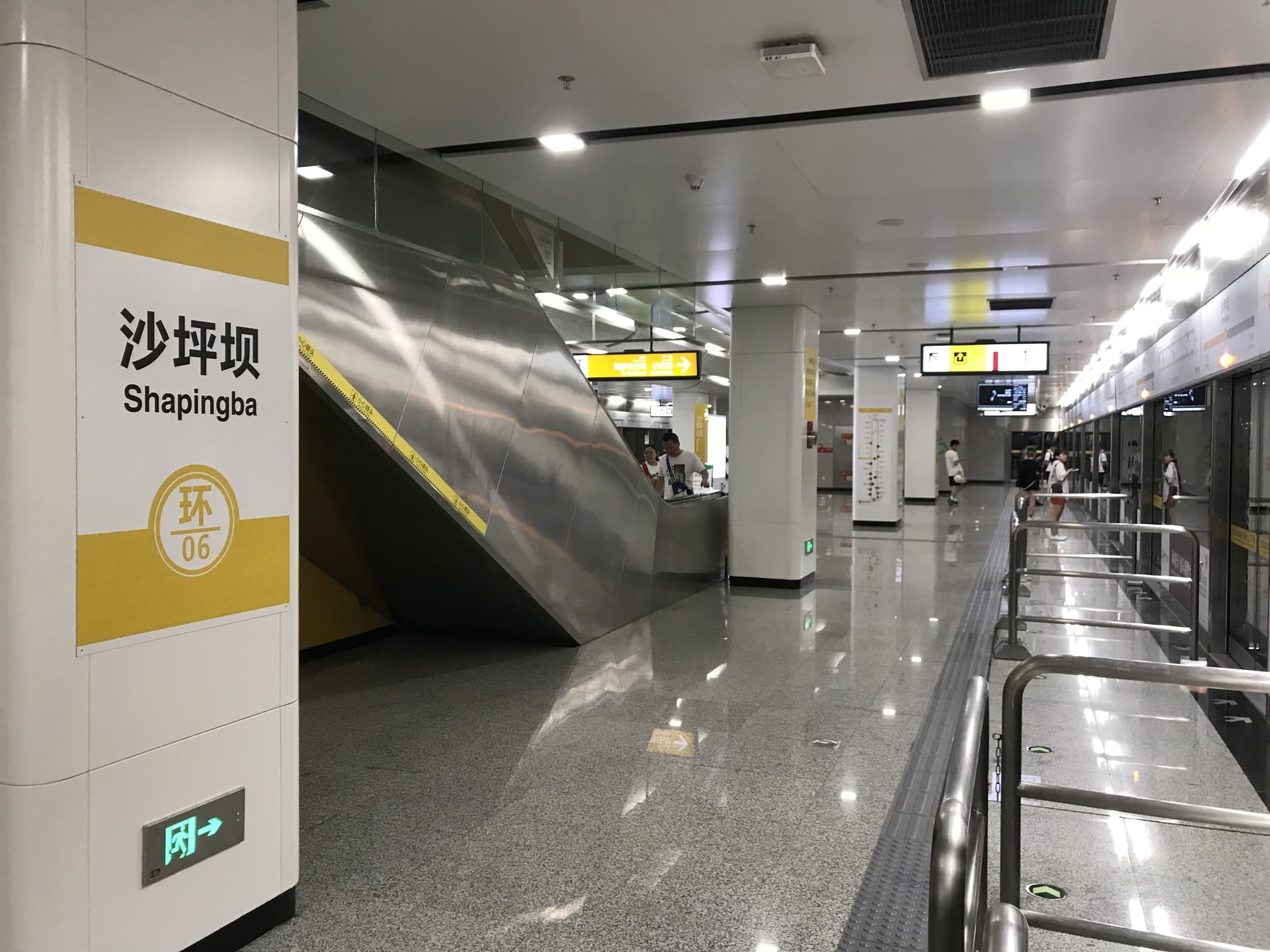 Interior of Shapingba Metro Station in Chongqing, China, showing modern subway platform signage and escalators