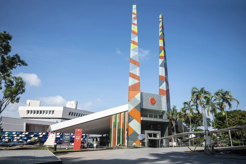 Exterior view of the Science Centre Singapore building with its colorful twin towers under a clear blue sky.