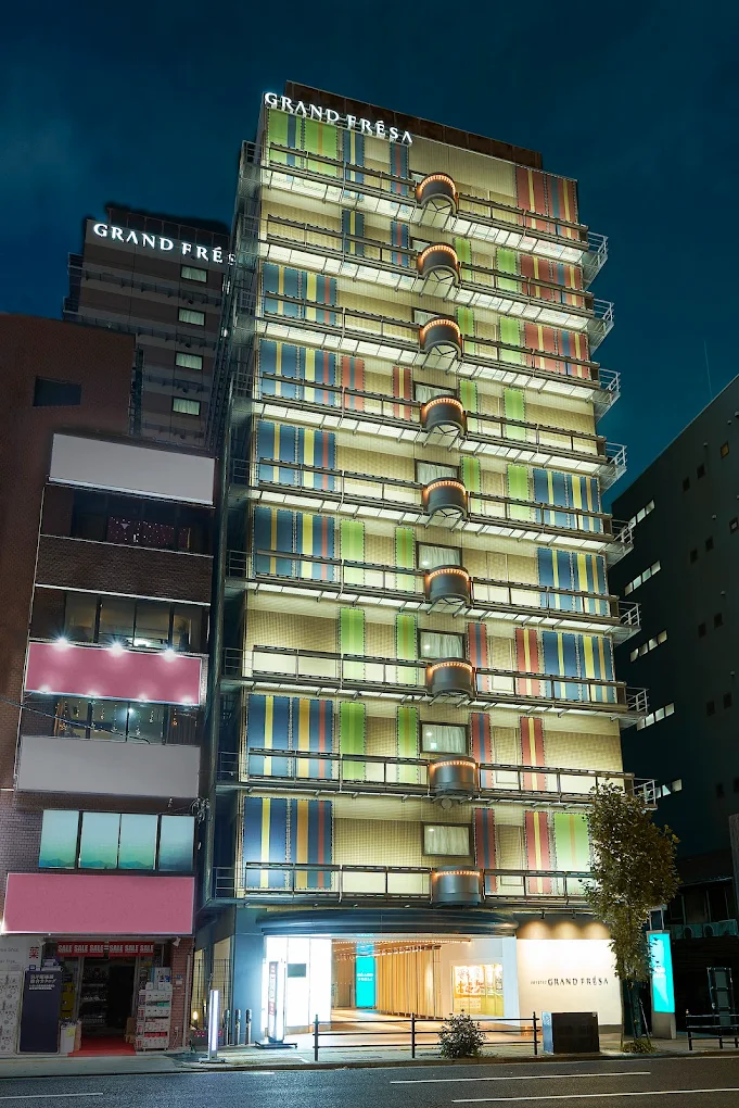 Exterior night view of Sotetsu Grand Fresa Osaka Namba hotel building with colorful modern facade near Namba Station in Osaka