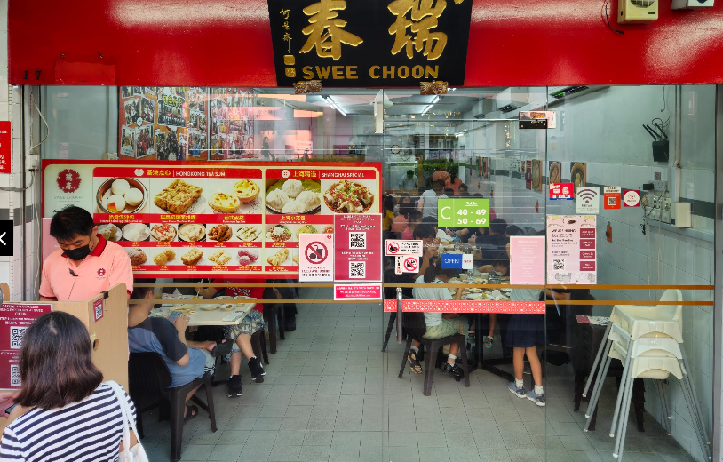Where to Find the Best Dim Sum in Singapore (Local Picks) 6 Exterior of Swee Choon Tim Sum Restaurant in Singapore with diners seated inside and dim sum menu boards displayed at the entrance.