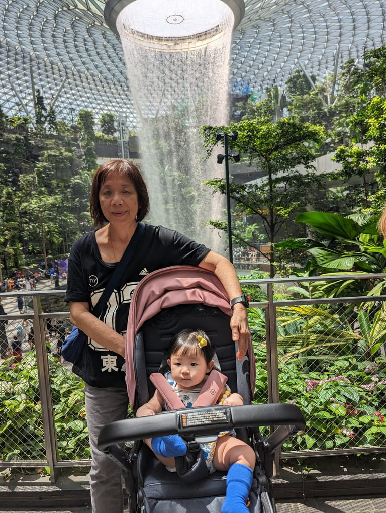 Visiting the Jewel Rain Vortex Singapore: Tips, Photos & What to Expect 7 Grandmother with toddler in stroller at the Jewel Rain Vortex inside Jewel Changi Airport Singapore.
