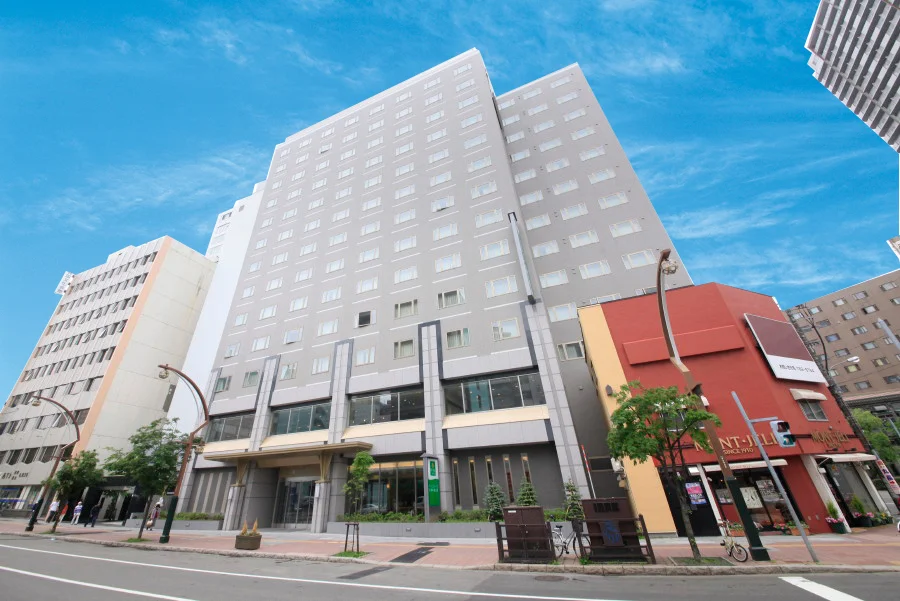Exterior view of Vessel Inn Sapporo Nakajima Park hotel under a bright blue sky in central Sapporo, Japan