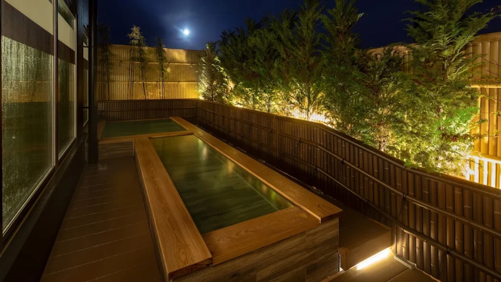 7 Best Hotels in Takayama Japan: Top Ryokans, Onsens & Family Stays 10 Outdoor onsen bath at Wat Hotel & Spa Hida Takayama illuminated at night in Japan