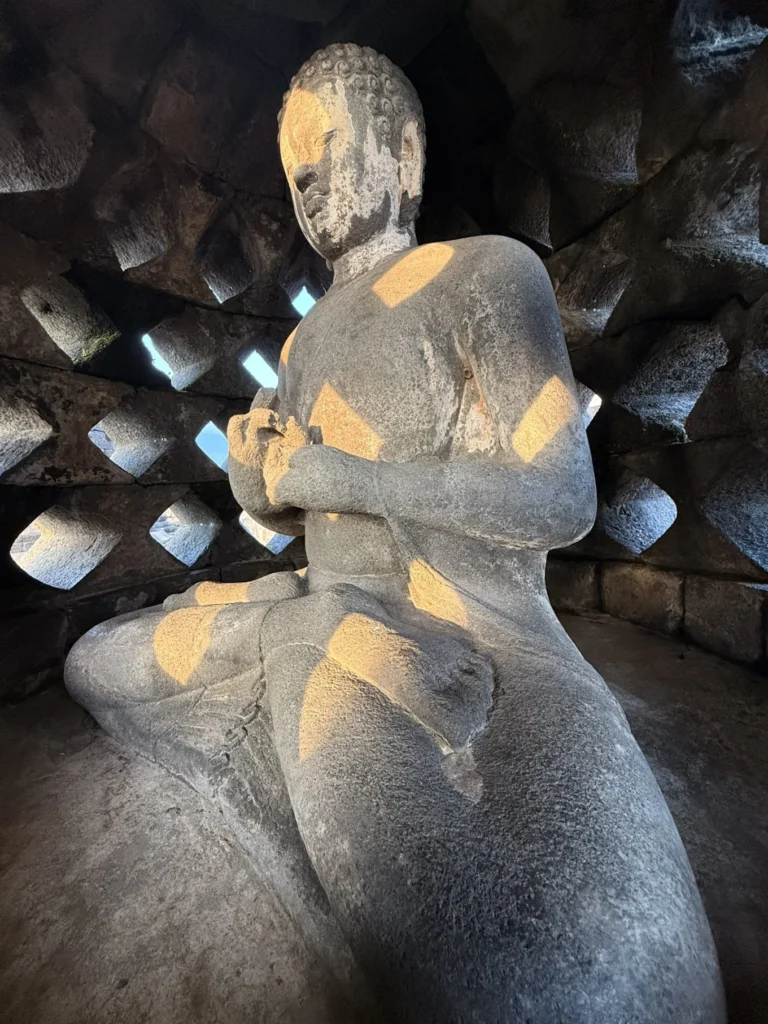 Amanjiwo Review: Is This Luxury Resort Near Borobudur Worth It? 36 Close-up of Buddha statue inside Borobudur stupa with sunrise light
