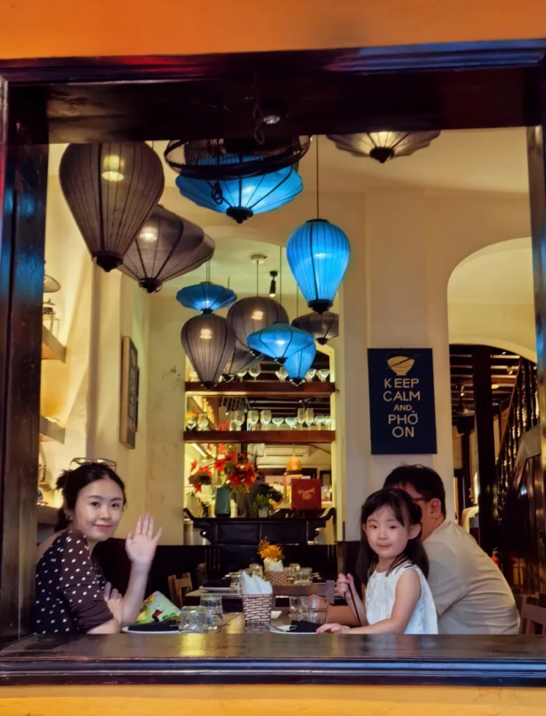Family dining at a lantern-lit restaurant in Hoi An Ancient Town during an evening in Vietnam