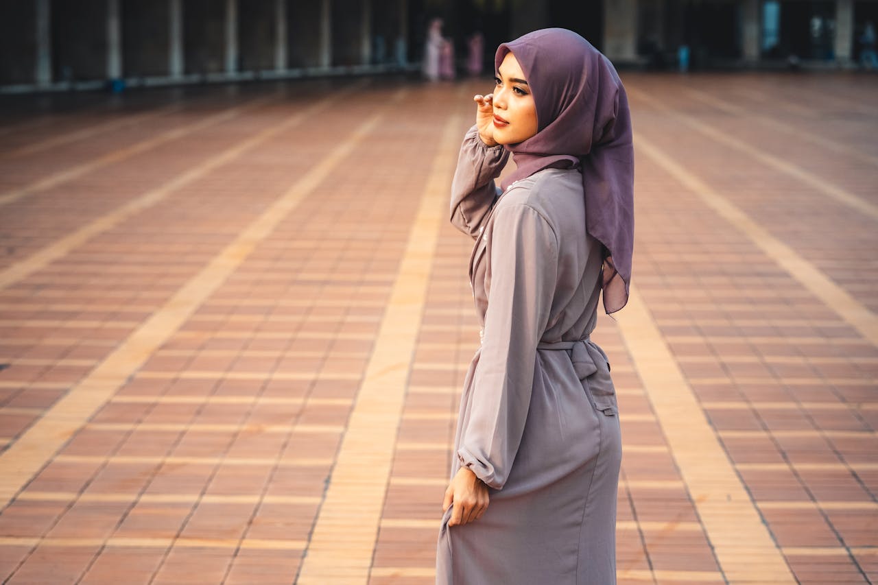 Muslim woman wearing a hijab standing outdoors in a modern urban plaza in South Korea