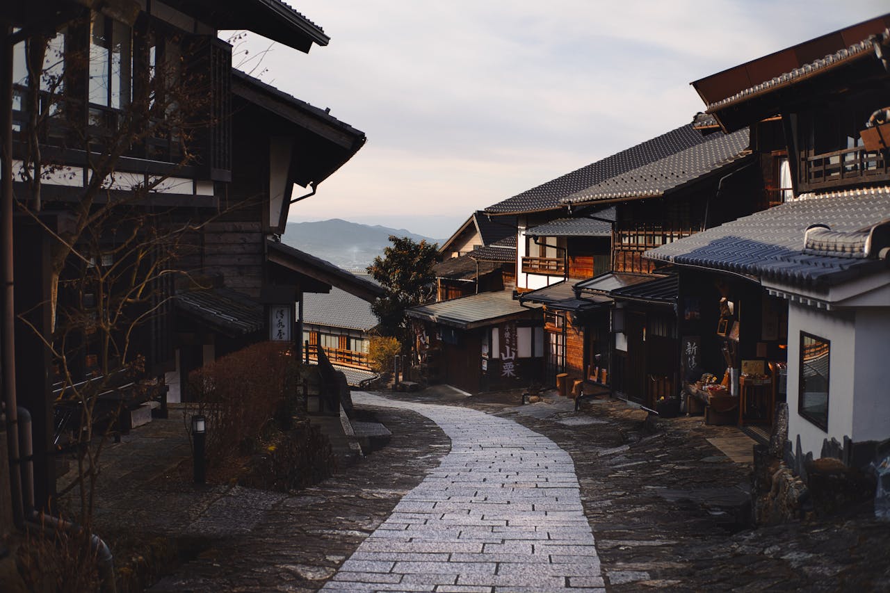 Traditional wooden street in historic Takayama Old Town with stone pathway and mountain views in Japan