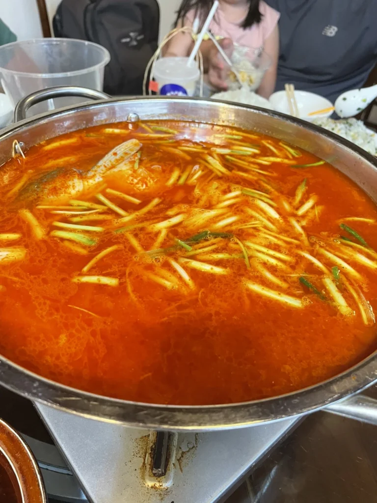 Qingyan Ancient Town Guide: Food, Night Views & Where to Stay 19 Large pot of Guizhou sour soup fish hotpot with spicy red broth.