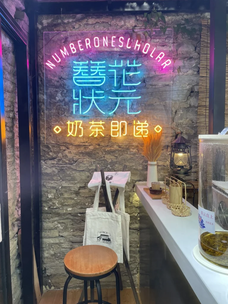 Qingyan Ancient Town Guide: Food, Night Views & Where to Stay 8 Neon milk tea shop sign inside Qingyan Ancient Town at night.