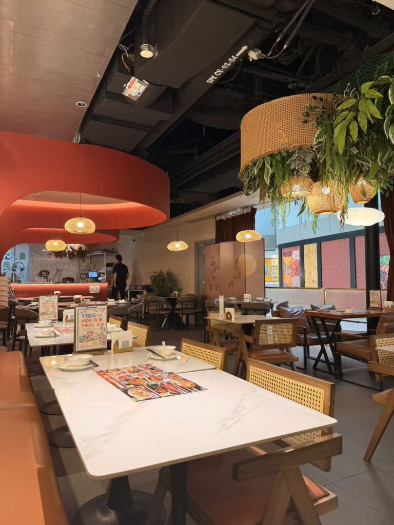 Interior dining area of Chengdu Bowl Changi Airport T3 with hanging plants and warm lighting