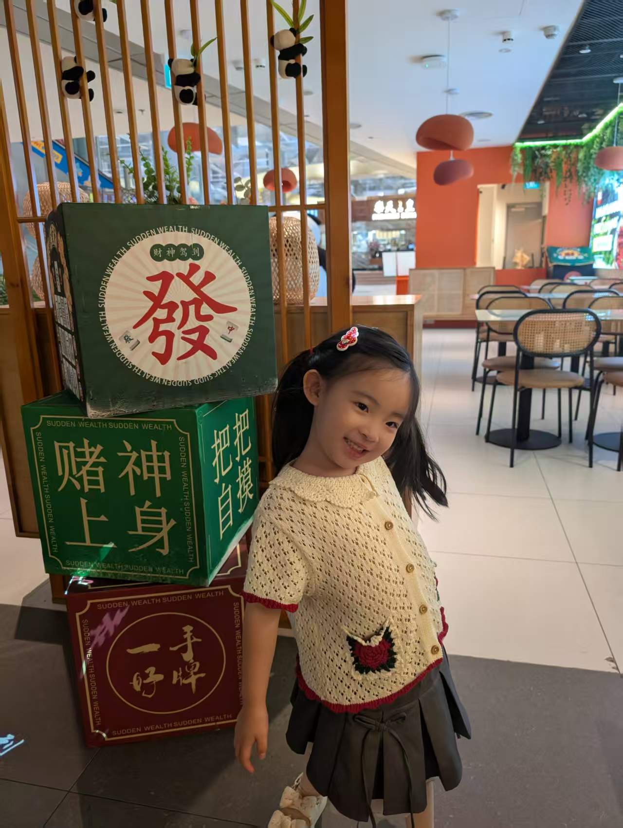 Young girl posing beside decorative Chinese prosperity-themed display inside Chengdu Bowl at Changi Airport Terminal 3