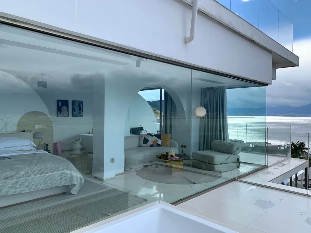Luxury suite at Dali Yuewan Hotel featuring floor-to-ceiling glass windows with panoramic Erhai Lake views and modern minimalist interiors