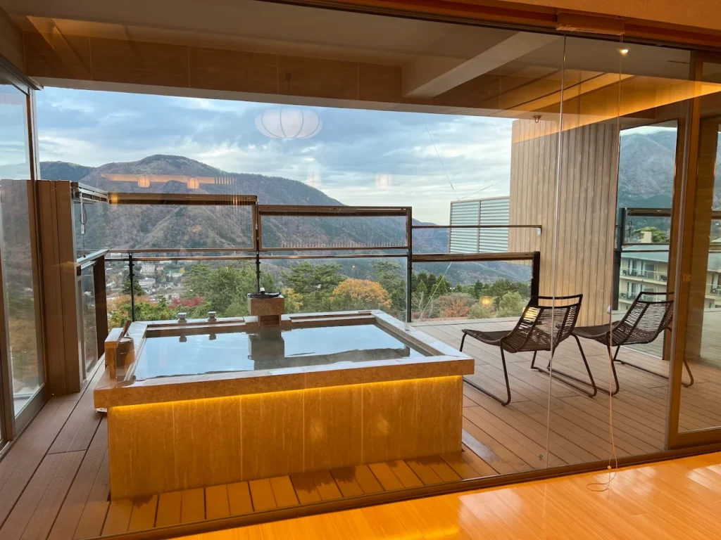 Private open-air onsen bath at Gen Hakone Gora overlooking the mountains of Hakone, with a modern suite design and panoramic valley views.