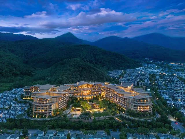 Hilton Dali Resort & Spa nestled at the foot of Cangshan Mountain with panoramic views of Dali city and surrounding landscapes at dusk