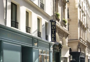 Exterior of Hôtel Gramont Opéra in Paris, featuring its elegant teal façade and classic Parisian streetscape.
