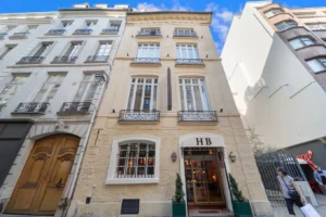 Exterior of Hôtel de la Bretonnerie in Le Marais, Paris, with classic cream stone façade and wrought-iron balconies.