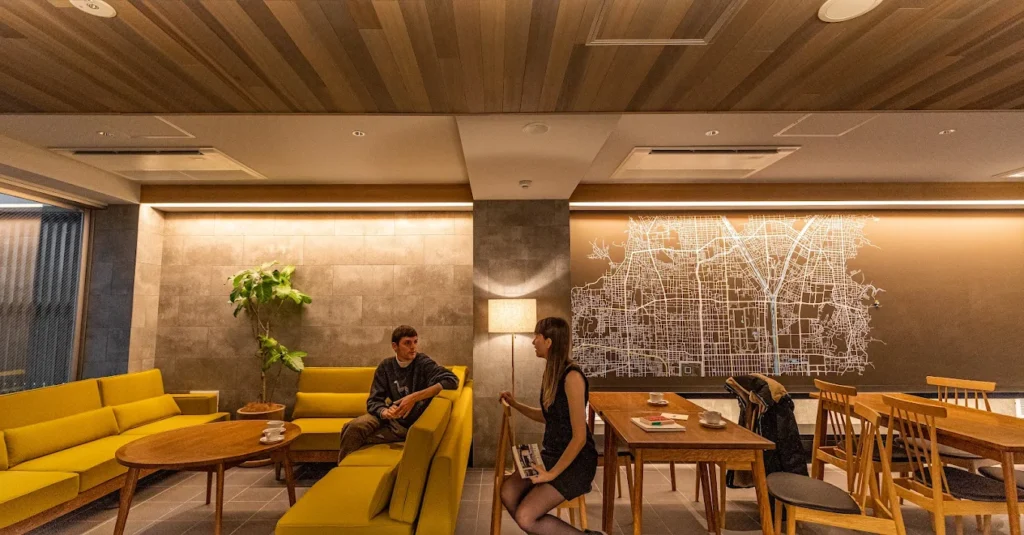Modern lounge area at Kefu Stay & Lounge Kyoto featuring contemporary seating, warm wood interiors, and a communal workspace for travelers
