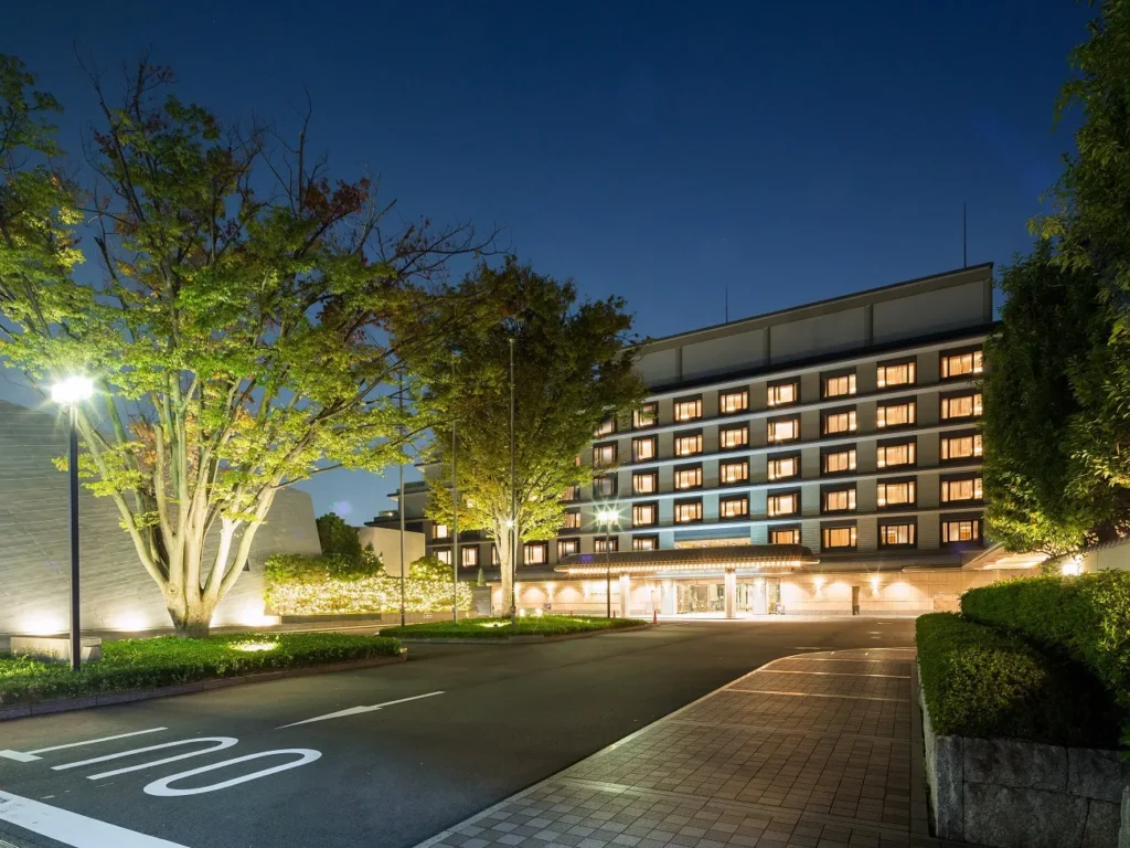 Kyoto Brighton Hotel illuminated at night with landscaped grounds and elegant architecture in central Kyoto, Japan