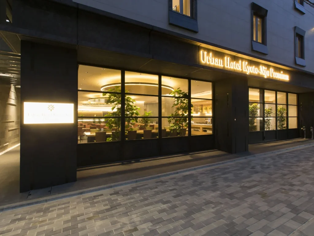 Urban Hotel Kyoto Nijo Premium entrance illuminated at night, featuring modern architecture and contemporary accommodations in Kyoto, Japan