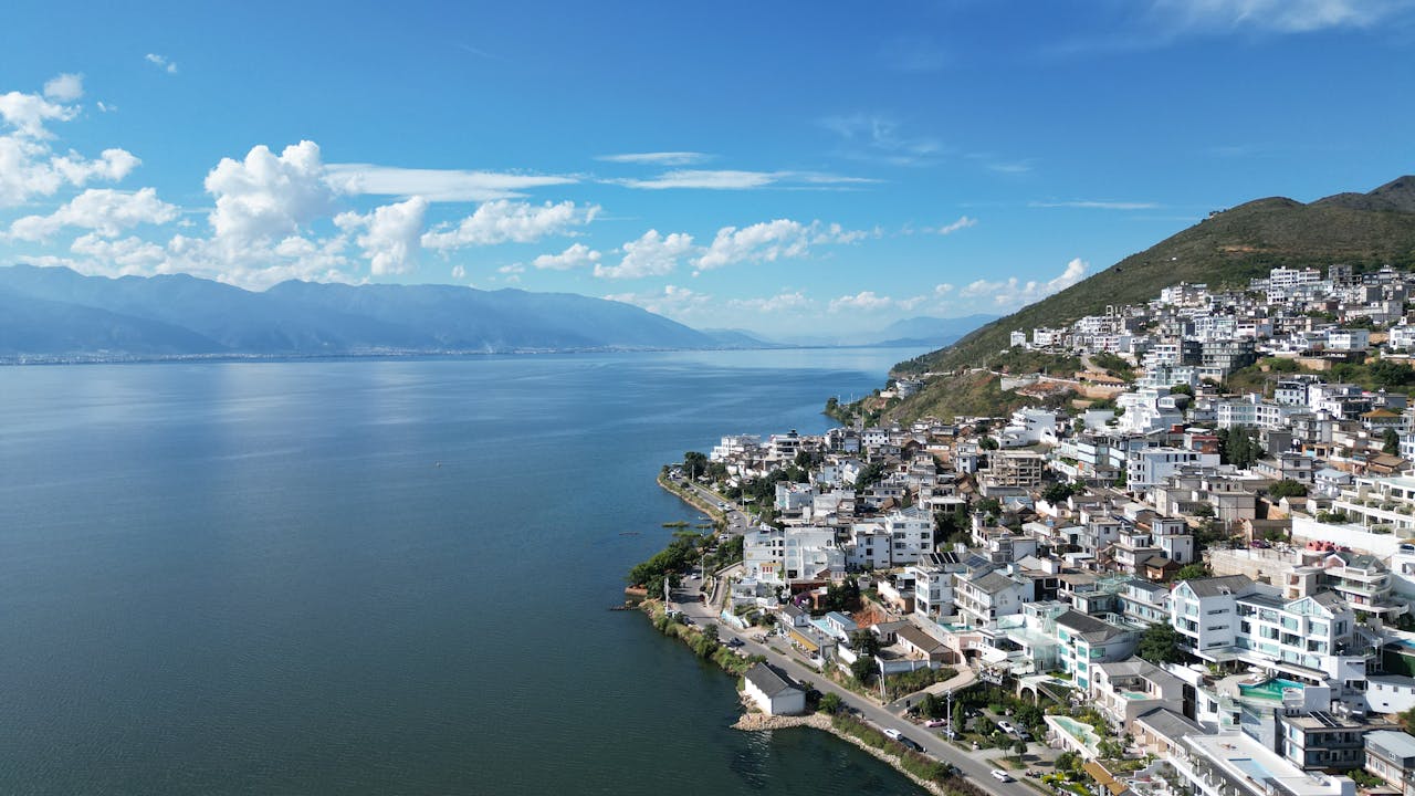 Aerial view of Erhai Lake and the lakeside villages of Dali, Yunnan, with mountain scenery and traditional Bai-style architecture along the shoreline